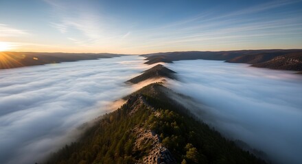 Fototapeta premium Dramatic golden light of dawn pierces a serene valley, revealing sharp mountain ridges through ethereal low-lying fog, creating a majestic natural pattern