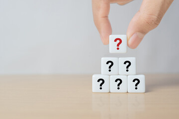 Hand hold dice in question mark mean what on wooden table background, column of wooden blocks with...
