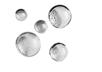 Droplets of clear liquid with bubbles against black background