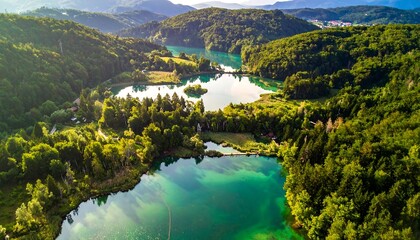 Aerial view of lakes nestled amidst vibrant green hills
