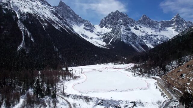 Drone view of snow covered mountains and forests in Bipeng Valley in Sichuan, China in sunny winter day, high angle view of beautiful winter landscape. 4k real time footage, travel concept.
