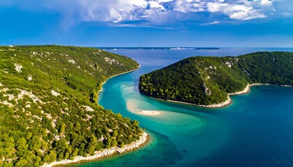 Aerial view of turquoise water and green hills under a blue sky