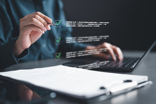 A person marking a digital checklist while working on a laptop, representing task management, document review, verification, and workflow efficiency in a modern business environment.