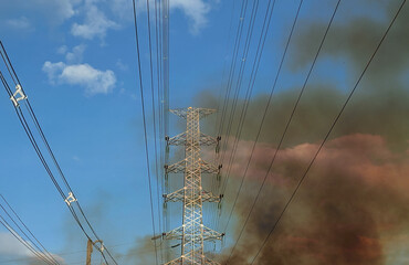 Wildfire is burning near power transmission tower line.