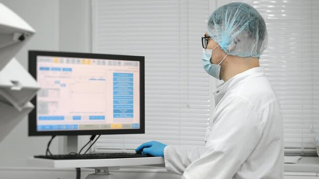 Scientist in blue gloves loading test tubes with blood samples into modern laboratory analyzer under bright clinical light in medical laboratory.