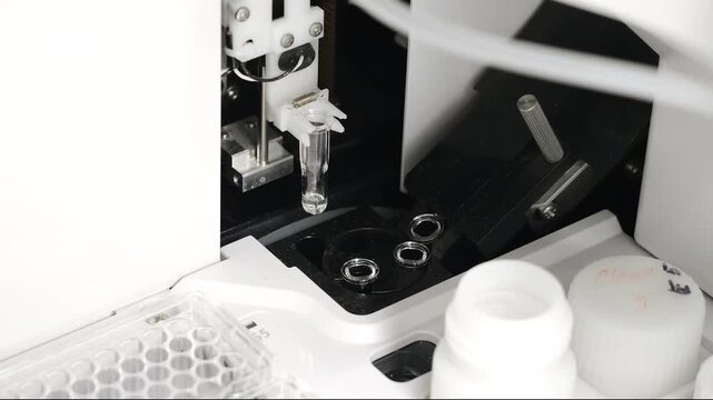 Close up of cuvettes inside an automatic biochemistry analyzer in clinical laboratory setting indoors for medical diagnostic testing and healthcare technology concepts.