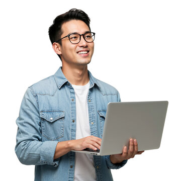 Smiling young asian man wearing glasses holding a laptop and looking upwards isolated on transparent background