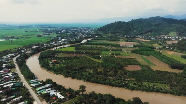 4K Aerial Drone Shot, La Nga River Valley and Ta Pao Mountains, Binh Thuan Rural Vietnam
panoramic view of the winding La Nga River, flanked by lush forested mountains and a patchwork of green fields 