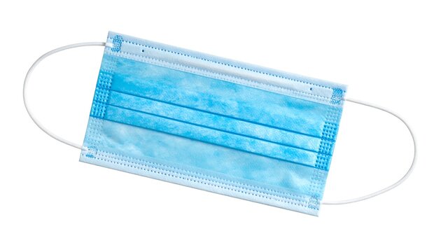 A close-up view of a disposable, light-blue face covering with ear loops, isolated on white