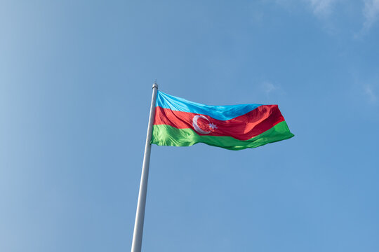 Azerbaijan flag waving in the blue sky. Azerbaijani national flag