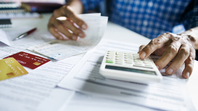 close up shot, asian man calculate expenses from credit card debt and many bills checking bank statement before paying debt