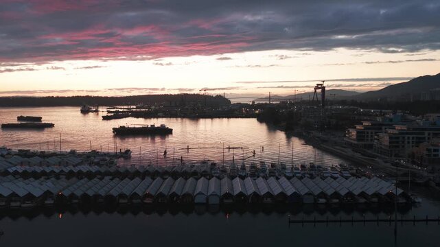 Low dolly aerial shot of covered boats at a marina during twilight in North Vancouver, British Columbia, Canada. 4K