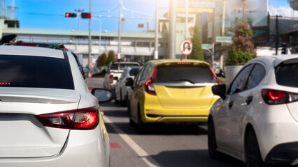 Rear side of white sedan car driving in the city. Many cars on the asphalt road in business time....