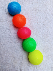 Five colorful naphthalene balls or camphor on white background in diagonal line. Sweet smelling fragrance effective for odor removal.