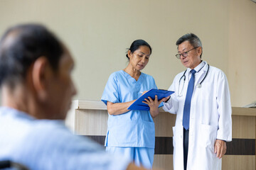 Team of Asian doctor and nurse is discussing and brainstorming on patient medical record after...