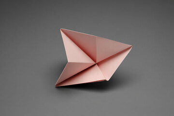 Delicate rose gold origami star folded from paper on a neutral grey background