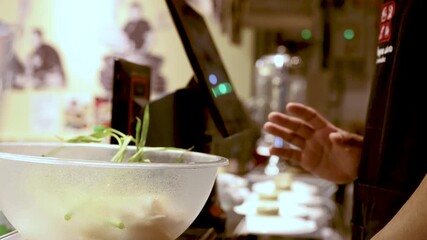 Restaurant Worker Using Touchscreen While Preparing Food in Kitchen