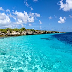 Crystal clear turquoise water meets a rocky shoreline under a blue sky