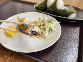 渓流魚の鮎。卵を持った子持ち鮎を唐揚げにした日本の料理と、海苔を巻いたおにぎり。卵のクローズアップ。