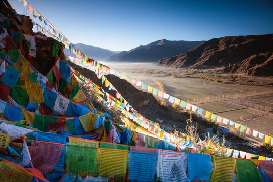 Tibetan prayer flags and valley at sunrise, Tibet