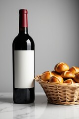 Bottle of red wine next to a basket of hot cross buns on a table