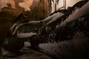 Monumental Buddha image Phra Atchana in subduing mara posture at Wat Sri Chum temple Sukhothai Historical Park, ancient stuccoed brick sculpture, thailand cultural heritage landmark
