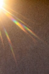 Obraz premium Warm sun flare with rainbow rays on textured wall