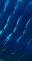 Blurred light flare. Gleam background. Blue ribbed color texture. Ocean water wave surface abstract luminosity optical pattern effect.