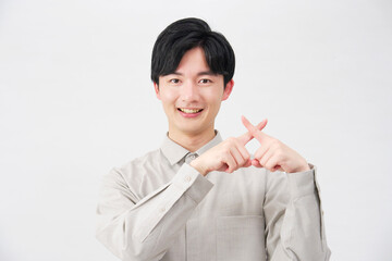 男性　指でばつ印のジェスチャー　20代　白背景