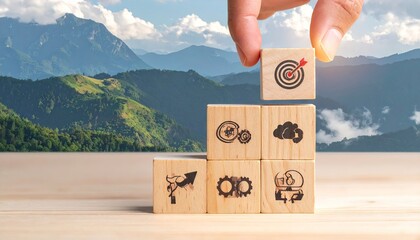 Hand Stacking Wooden Blocks Toward Target Symbol Against Mountain Landscape Success Concept, Wood Grain Texture, Business Goal Focus, and Clarity