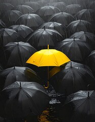 A vibrant yellow umbrella stands out amidst a sea of closed black umbrellas in the rain. The composition suggests individuality