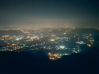 From afar, Dehradun glows like a quiet constellation, its city lights scattered across the valley as if stitched into the night.