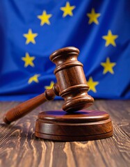 A wooden gavel rests on a table, with a blue flag featuring gold stars in the background. The flag is slightly blurred