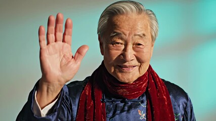 Portrait of smiling elderly Asian man in traditional clothing. Happy senior grandfather with grey hair gesturing while talking - Powered by Adobe