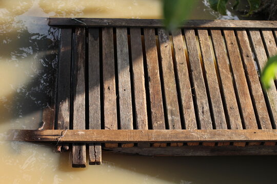 Wooden dock floating on water with natural sunlight and shadows