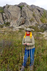 Portrait of a beautiful mature female tourist walking along the rocks in the Ural Mountains on a summer day