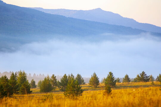 picturesque fog in the valleys of the Ural Mountains on a summer morning. Lake Talcas