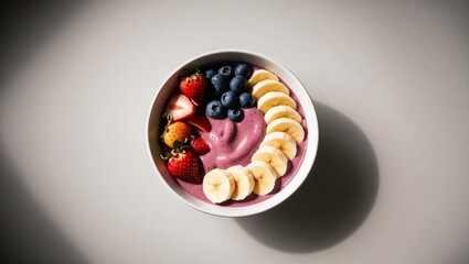 Vibrant & Healthy Purple Smoothie Bowl Topped with Fresh Organic Strawberries, Blueberries, and Sliced Bananas