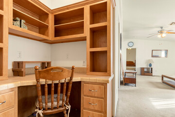 In a living room, there is a wooden desk accompanied by a chair