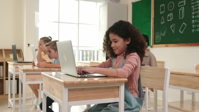 American girl learning about coding engineering prompt while diverse students sitting at STEM technology class. Multicultural children working on laptop to generated AI by using software. Pedagogy.