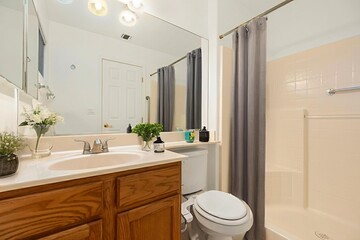 A fullyequipped bathroom featuring a sink, toilet, shower, and mirror