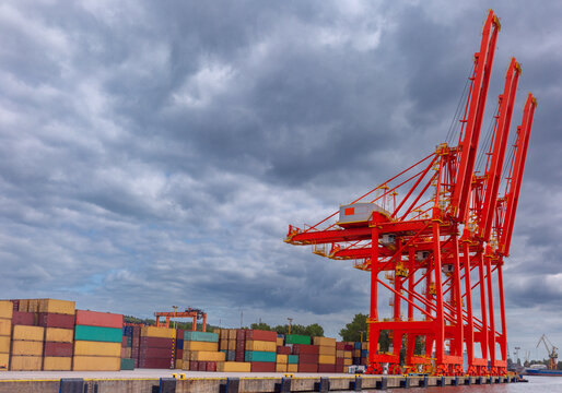 Red ship-to-shore cranes and container stacks at Baltic Container Terminal in Gdynia, Poland - Powered by Adobe