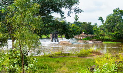 Obraz premium Scenic View of a check dam with Water Cascading over Rocks at Cheramangalam check dam in Palakkad, Kerala,