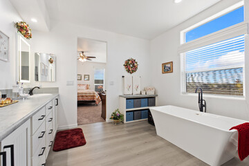 A welldesigned bathroom that features a tub, sink, mirror, and window