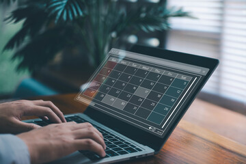 Digital calendar on laptop screen with highlighted dates, symbolizing schedule planning, time management, productivity, event organization, and efficient business or personal task scheduling.