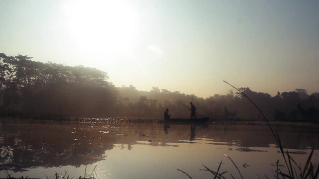 Forest Silhouettes Reflected On Idyllic River With Sailing Person During Sunset. Aerial Shot. A man in the middle of the lake boat during morning fishing 