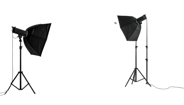 Two photography softboxes stand on tripods against a dark background