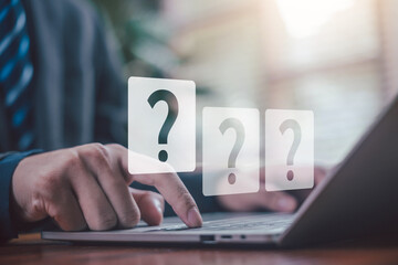 A person using a laptop with question tech, Brainstorming, and problem-solving. Concept of asking, answering, and business FAQs. question mark Thinking and wondering.