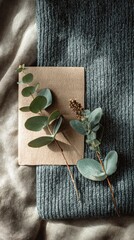 Warm Sunlight on Rustic Journal with Eucalyptus Sprigs and Cozy Teal Fabric.