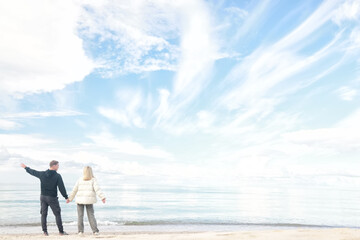 man and woman, couple in love on the seashore spring or autumn view seasonal photo in warm clothes